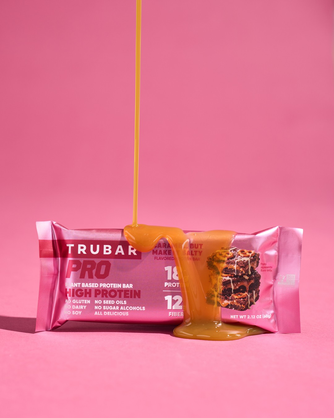 Pink Trubar with a caramel-colored pour against a pink background